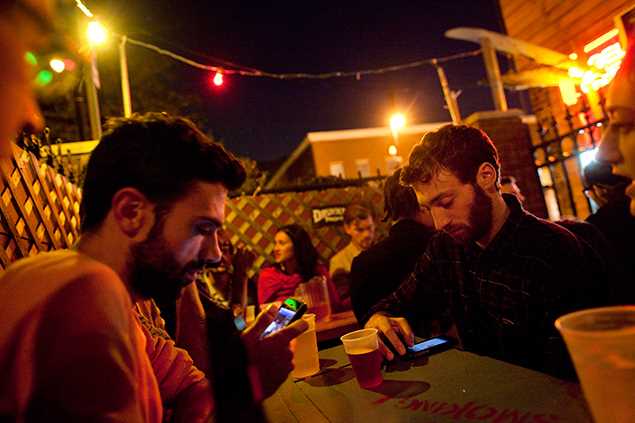 Grupo de amigos comemora um aniversário em um bar de Nova York; para alguns, smartphones podem ter "ido longe demais"