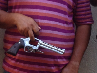 Suspeito segura a arma que teria sido usada no crime (Foto: Polícia Civil do Pará / Divulgação)