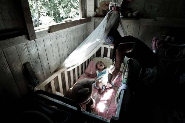 Rosana Vieira Noronha coloca sua filha Adriele no berço na casa onde vivem, no Quilombo dos Camargos de Votorantim interior de São Paulo. Foto: Epitácio Pessoa / Estadão