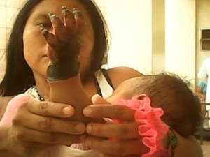 Mãe mostra mão de bebê indígena após aplicação de soro (Foto: Arquivo pessoal)