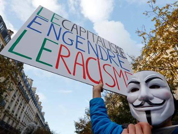 Protesto: Manifestante segura cartaz dizendo "Capitalismo gera racismo" durante ato anti-racista em Paris, em 30 de novembro de 2013. Foto: AFP - François Guillot