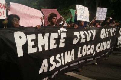 Índios e outros manifestantes carregam faixa na avenida Paulista