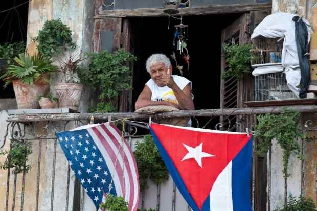 Cubano dá um jóia em varanda decorada com bandeiras de Cuba e dos Estados Unidos no dia 16 de janeiro