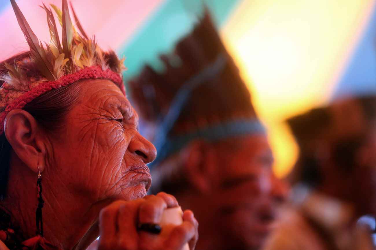 Acampada durante a Mobilização Nacional Indígena, rezadora Guarani Kaiowa observa parlamentares discursando. Foto: Lunaé Parracho / MNI