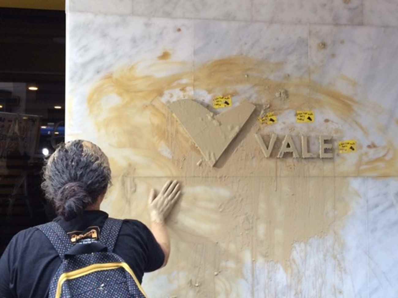 Manifestante suja parede da sede da Vale, no Centro do Rio (Foto: Cristina Boeckel/G1)
