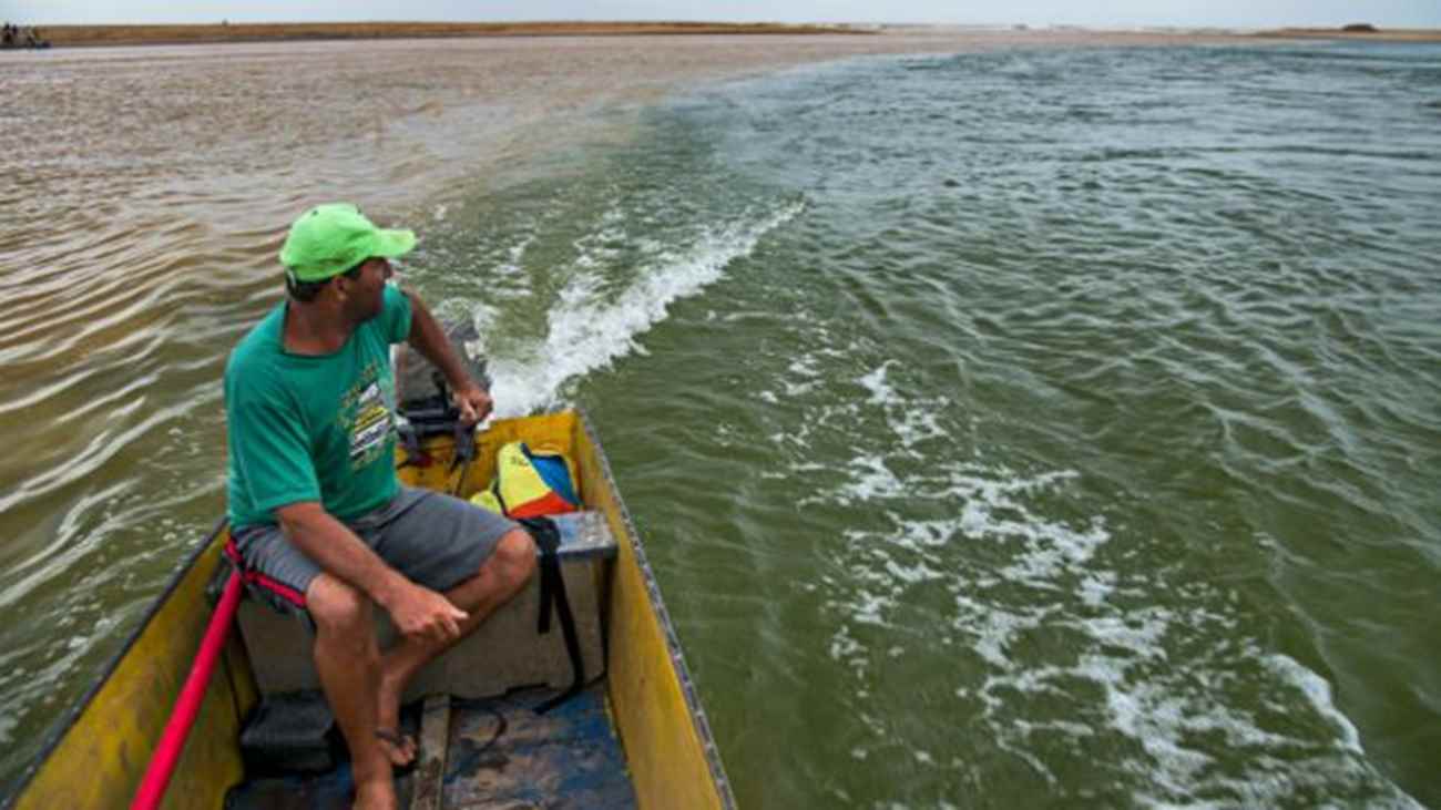 Em Regência, pescador observa o encontro da lama com a água do rio, já chegando ao mar