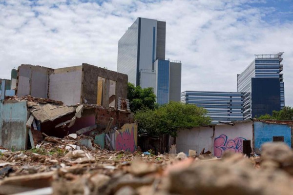 De um lado, a Vila Autódromo sobrevive entre casas derrubadas por retroescavadeiras e entulhos, do outro, o Parque Olímpico atinge 97% da sua construção.. Foto de Mauro Pimentel